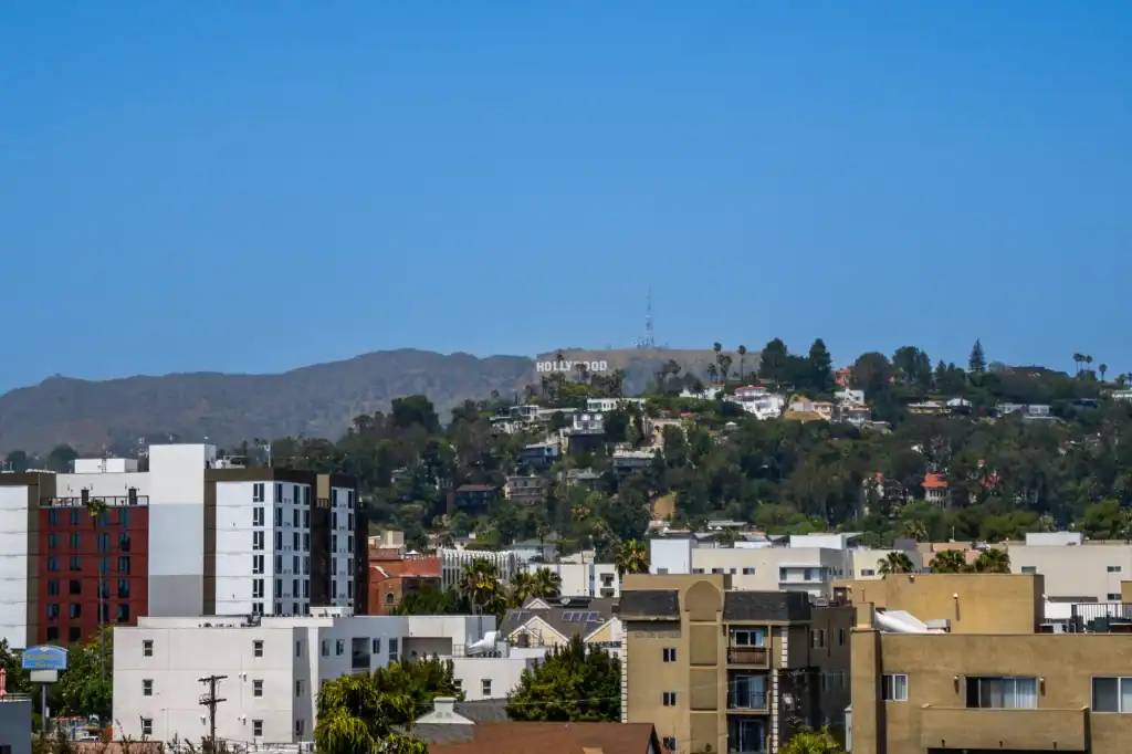 Bright sunset over Los Angeles skyline with hills in the background, showcasing urban landscape and.
